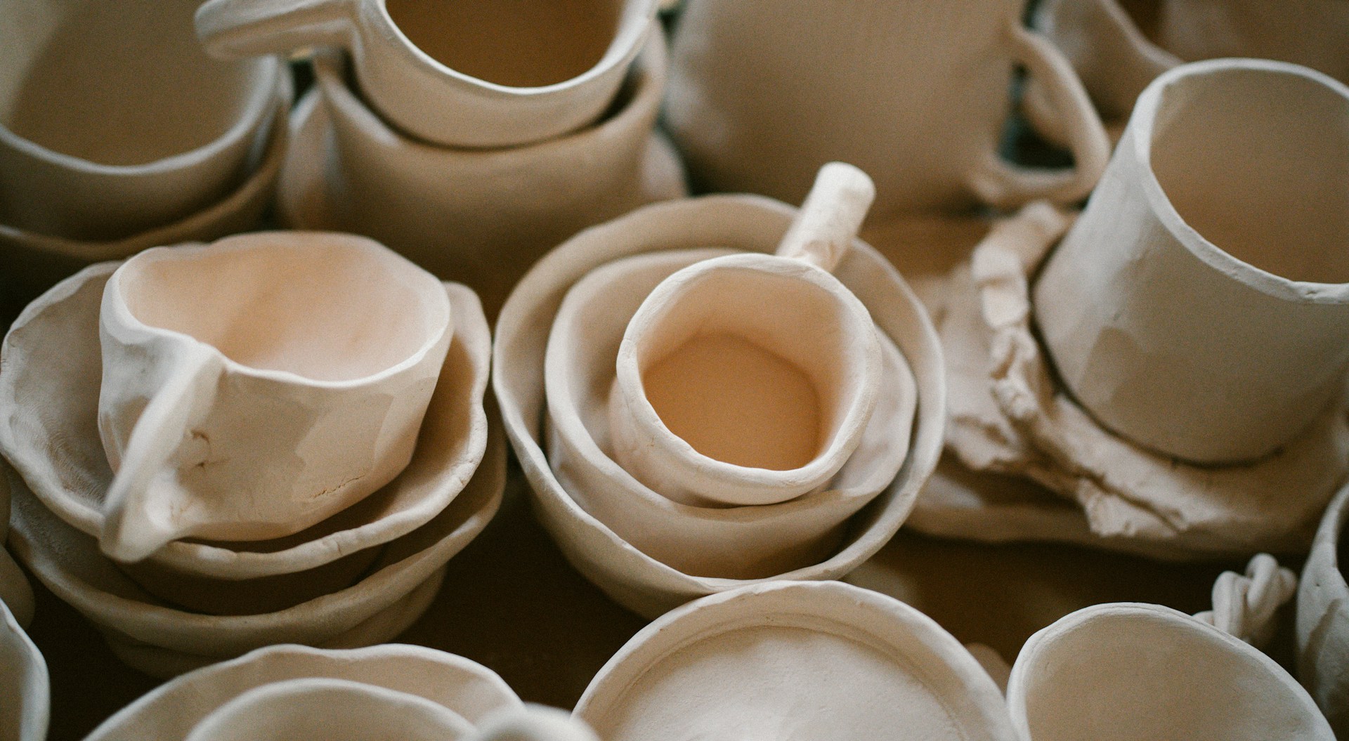 A pile of white cups and saucers sitting on top of a table