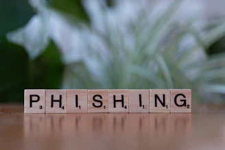 A wooden block spelling phishing on a table