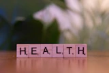 A wooden block spelling the word health on a table