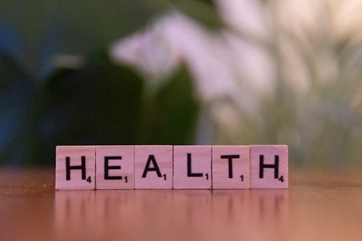 A wooden block spelling the word health on a table
