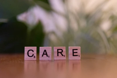 A wooden block spelling care on a table