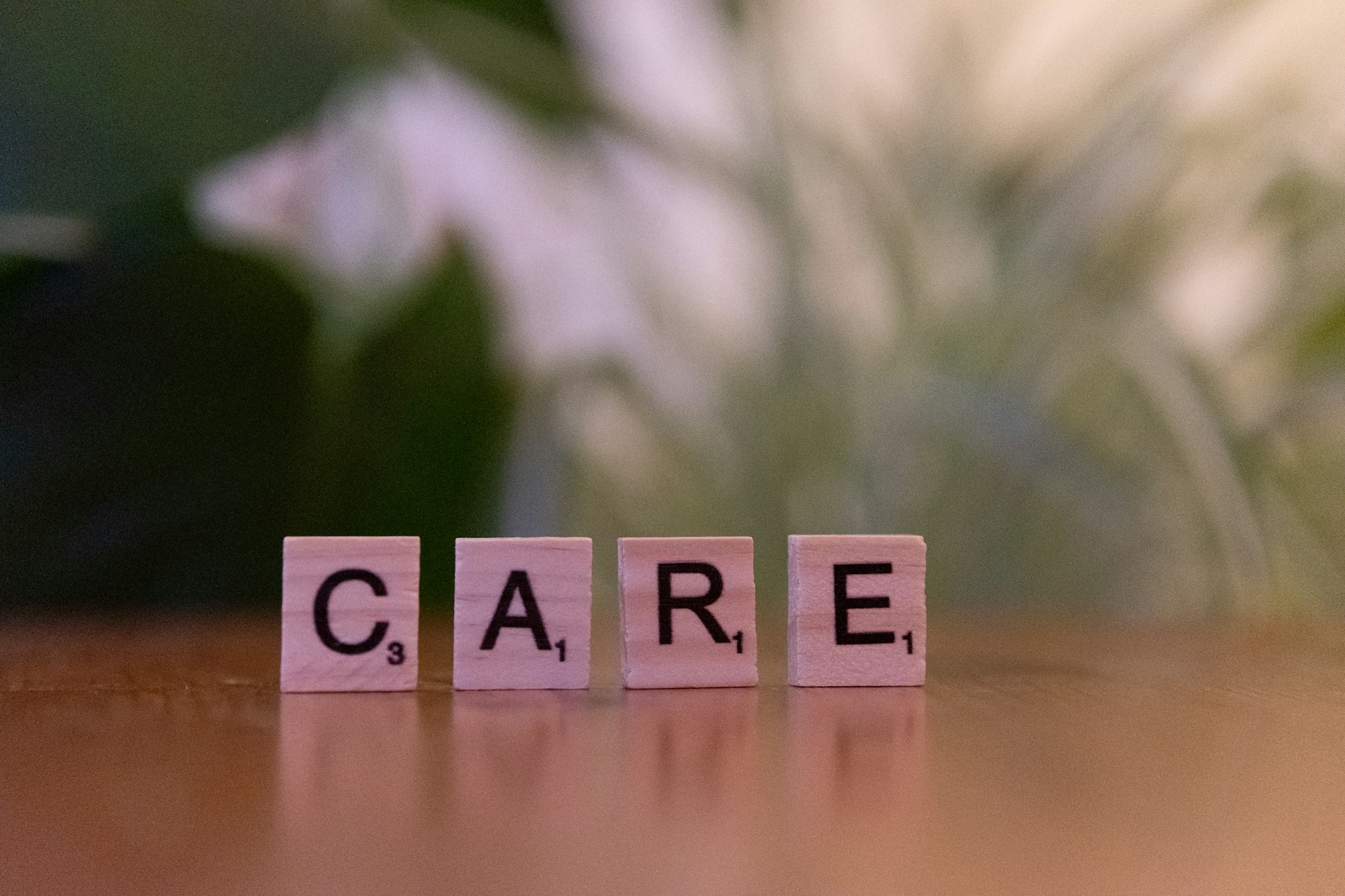 A wooden block spelling care on a table