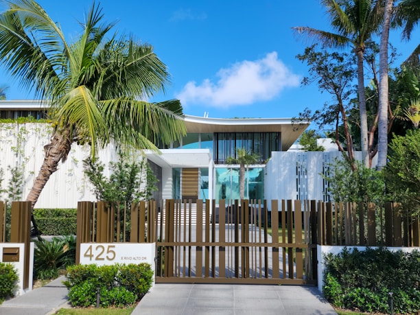 A house with a wooden fence and palm trees