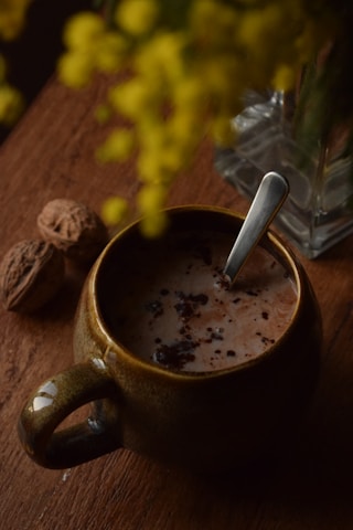 A cup of hot chocolate with a spoon in it