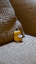 A yellow rubber duck sitting on a couch