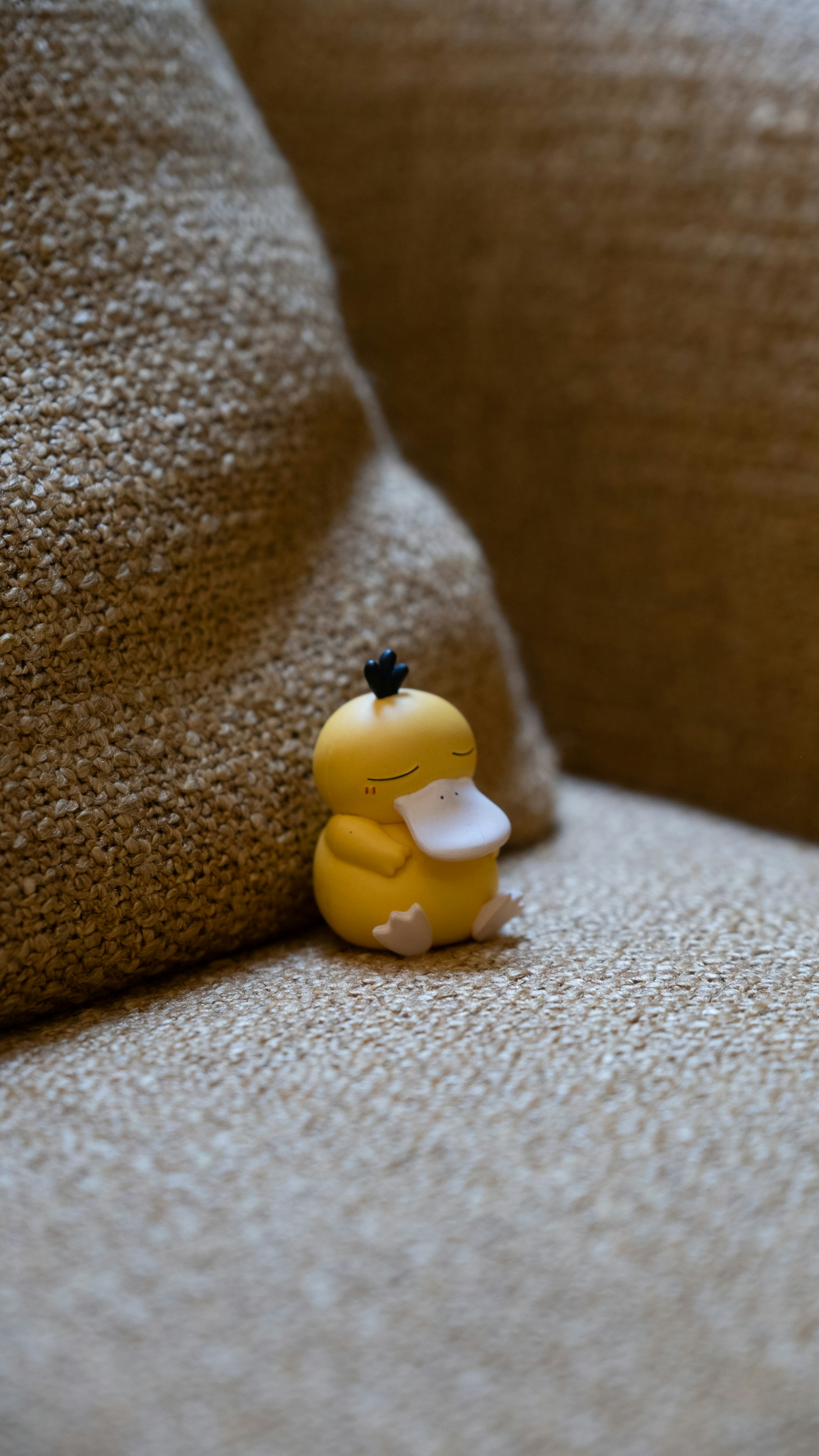 A yellow rubber duck sitting on a couch