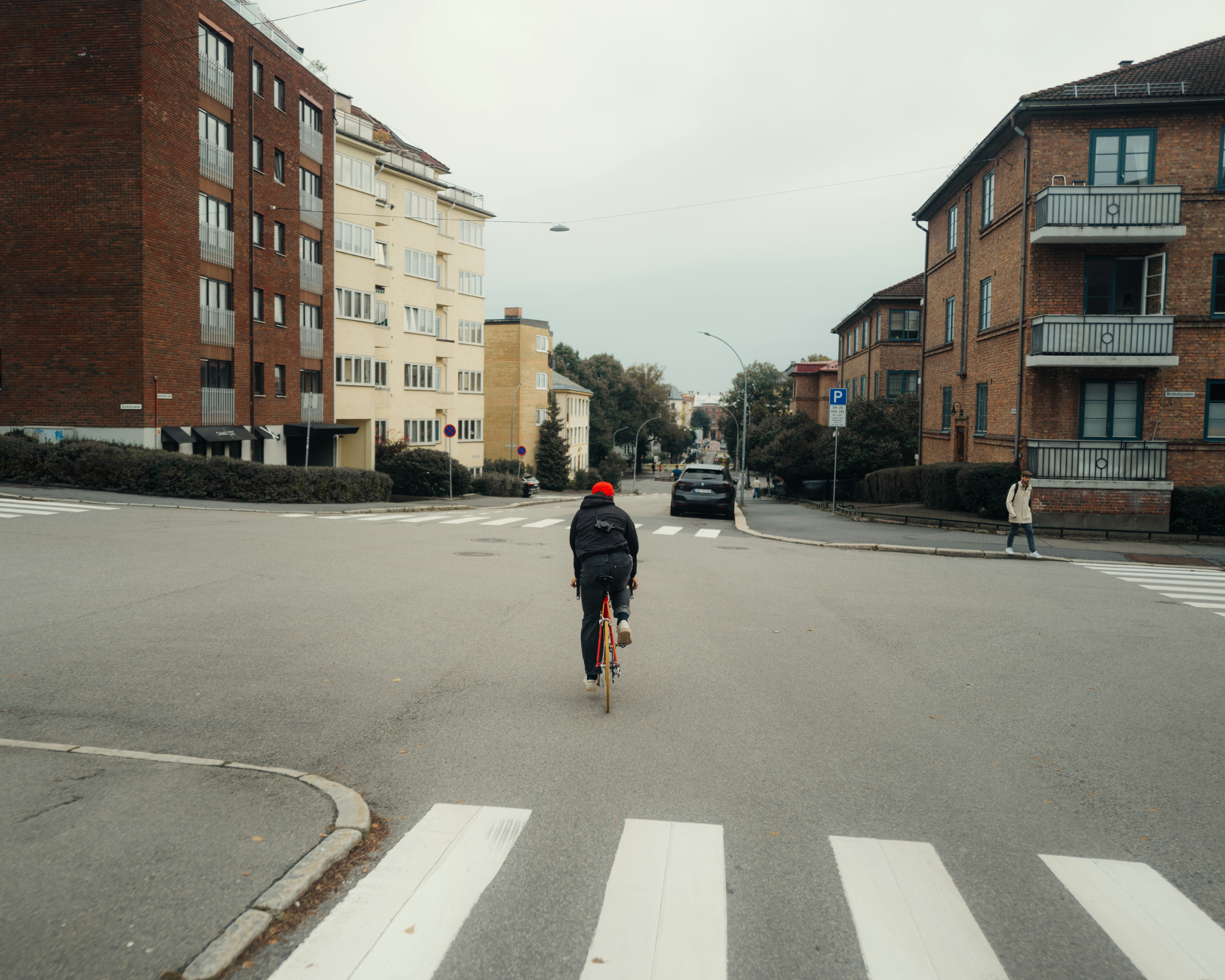 A man riding a skateboard down a street next to tall buildings
