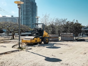 A yellow forklift is parked in the sand