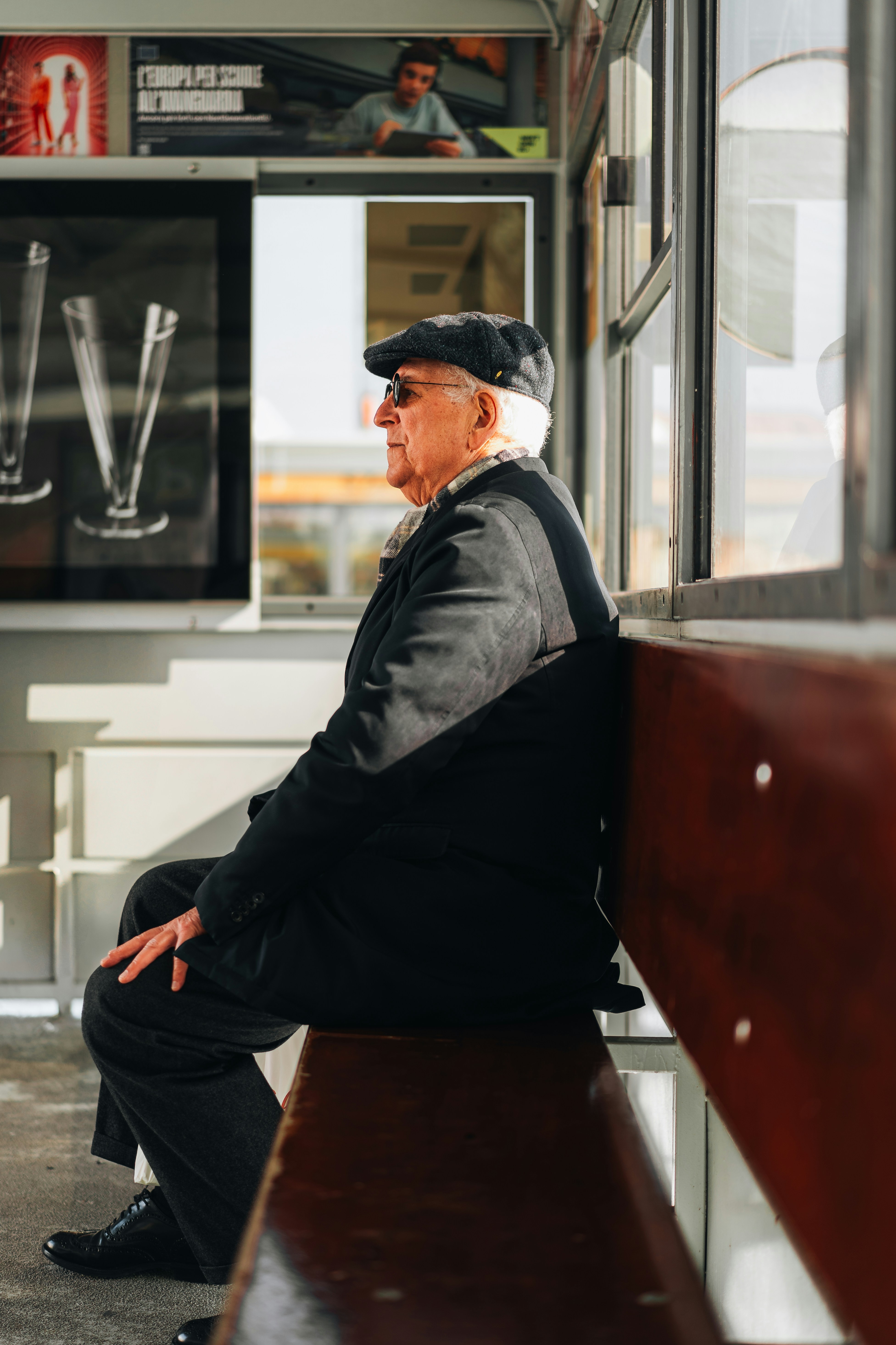 A man sitting on top of a wooden bench