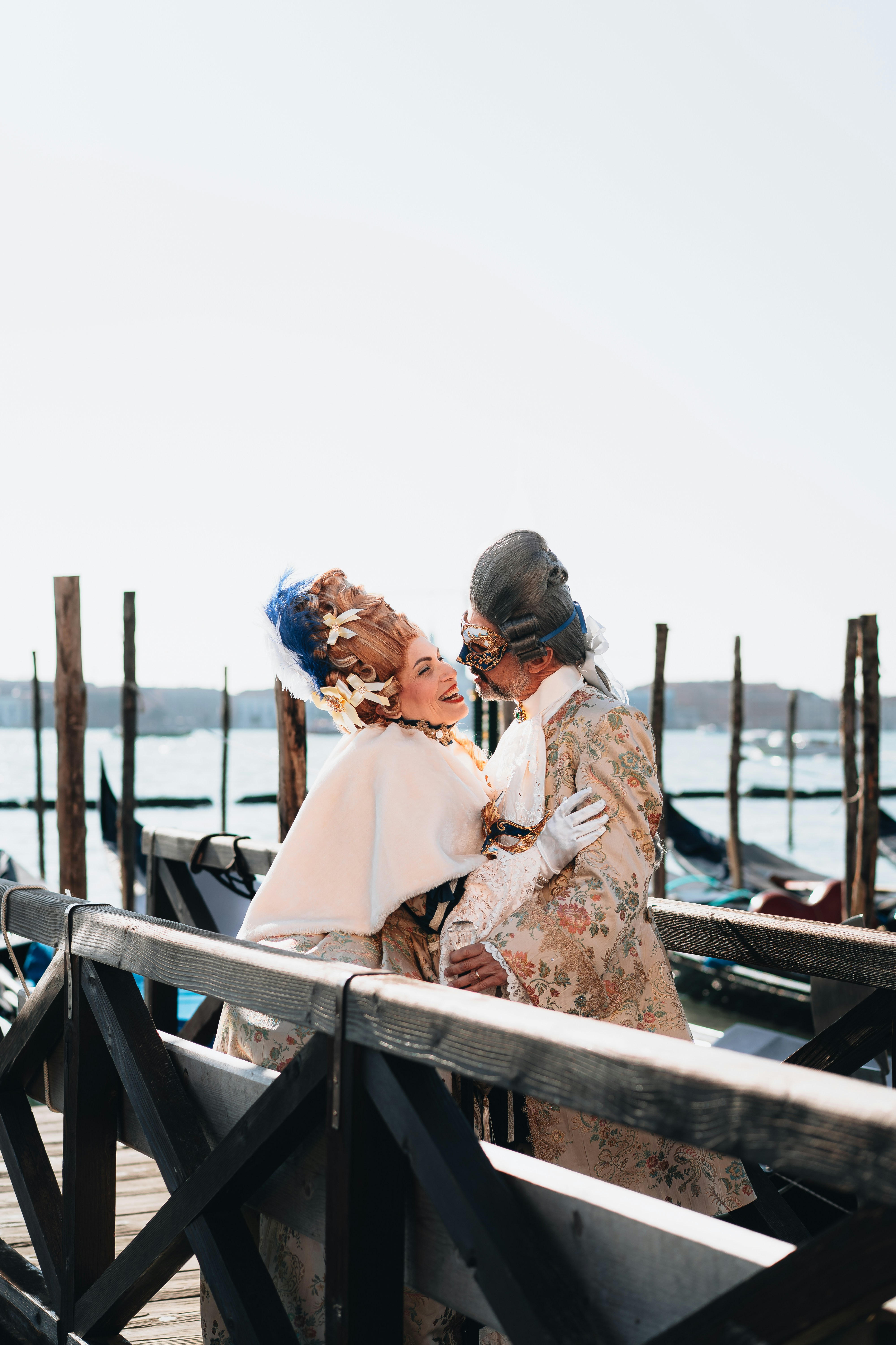 A couple of women standing next to each other on a pier