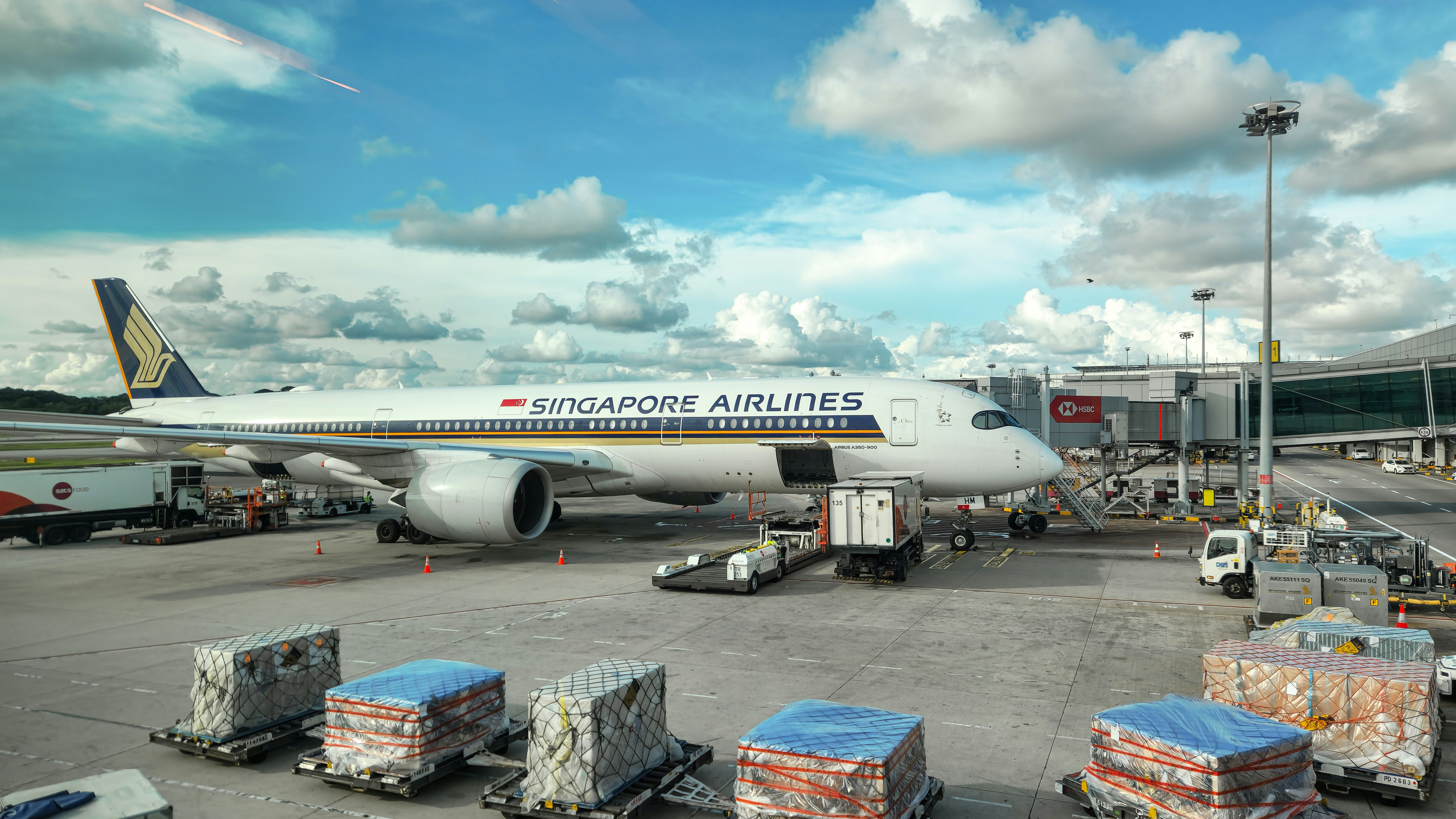 A large jetliner sitting on top of an airport tarmac, The Singapore Airlines Airbus A350-900 is a state-of-the-art wide-body aircraft designed for long-haul flights. Known for its fuel efficiency and advanced aerodynamics, this modern jet is part of Singapore Airlines