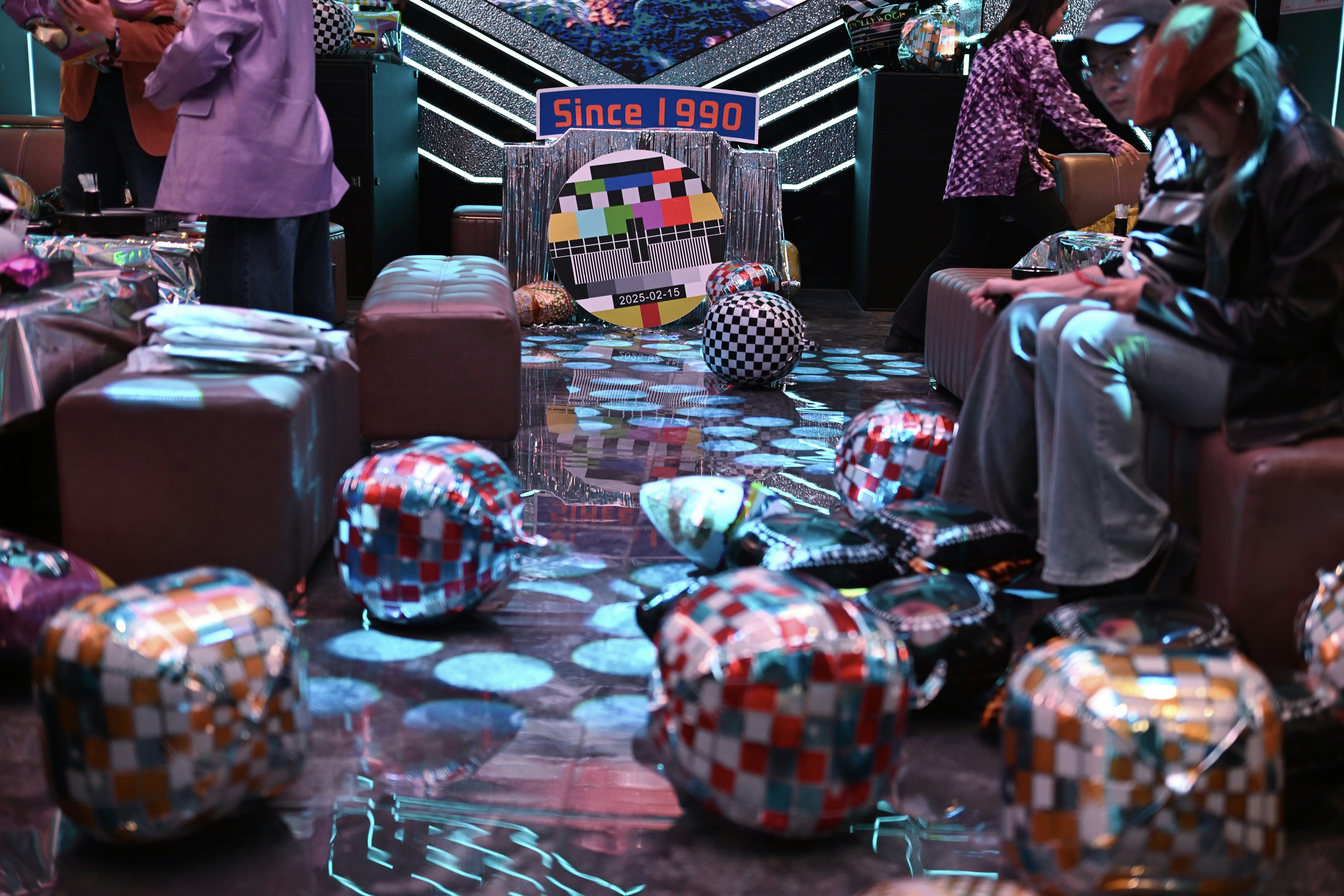 A group of people standing around a room filled with furniture