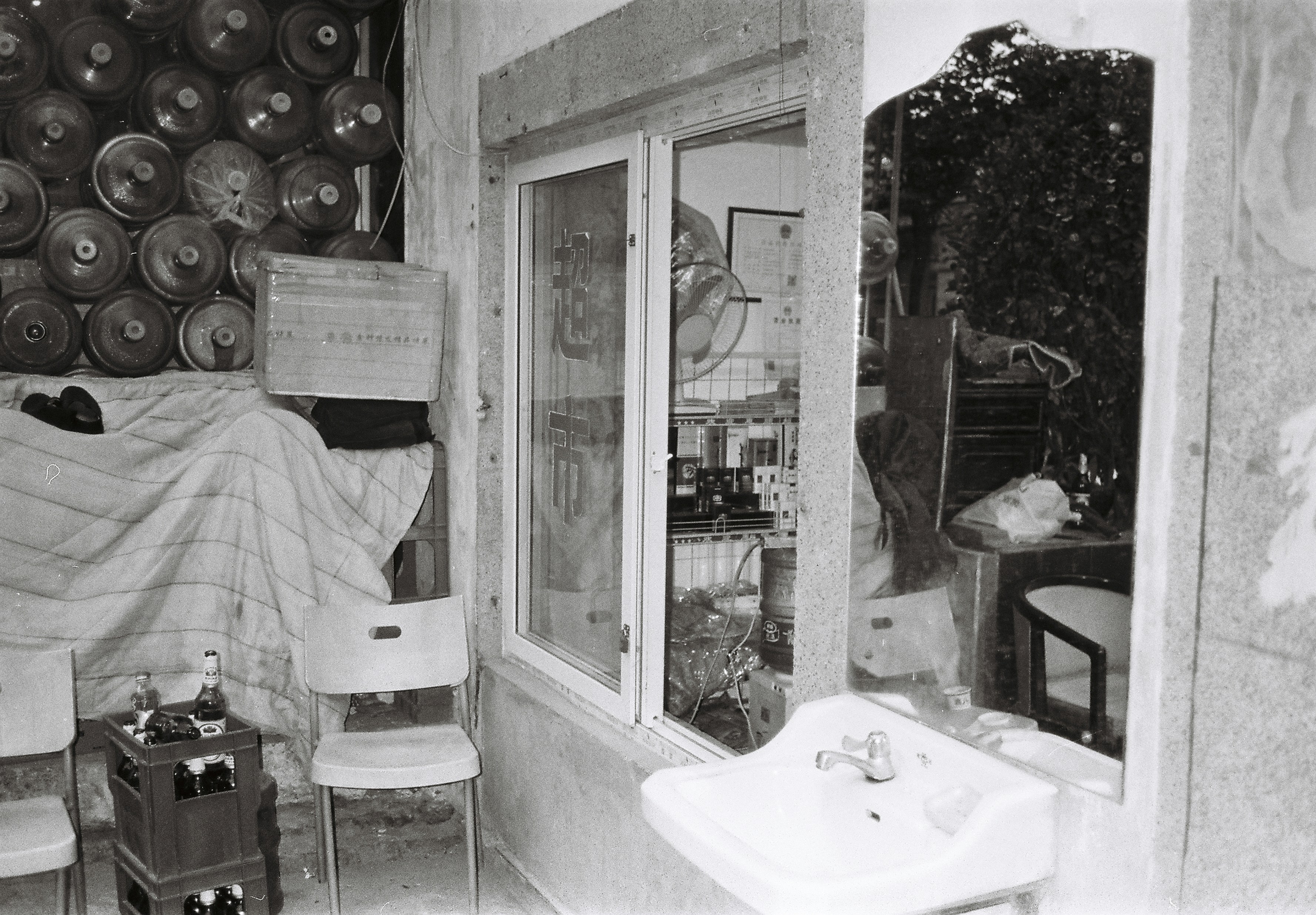 A black and white photo of a room filled with furniture
