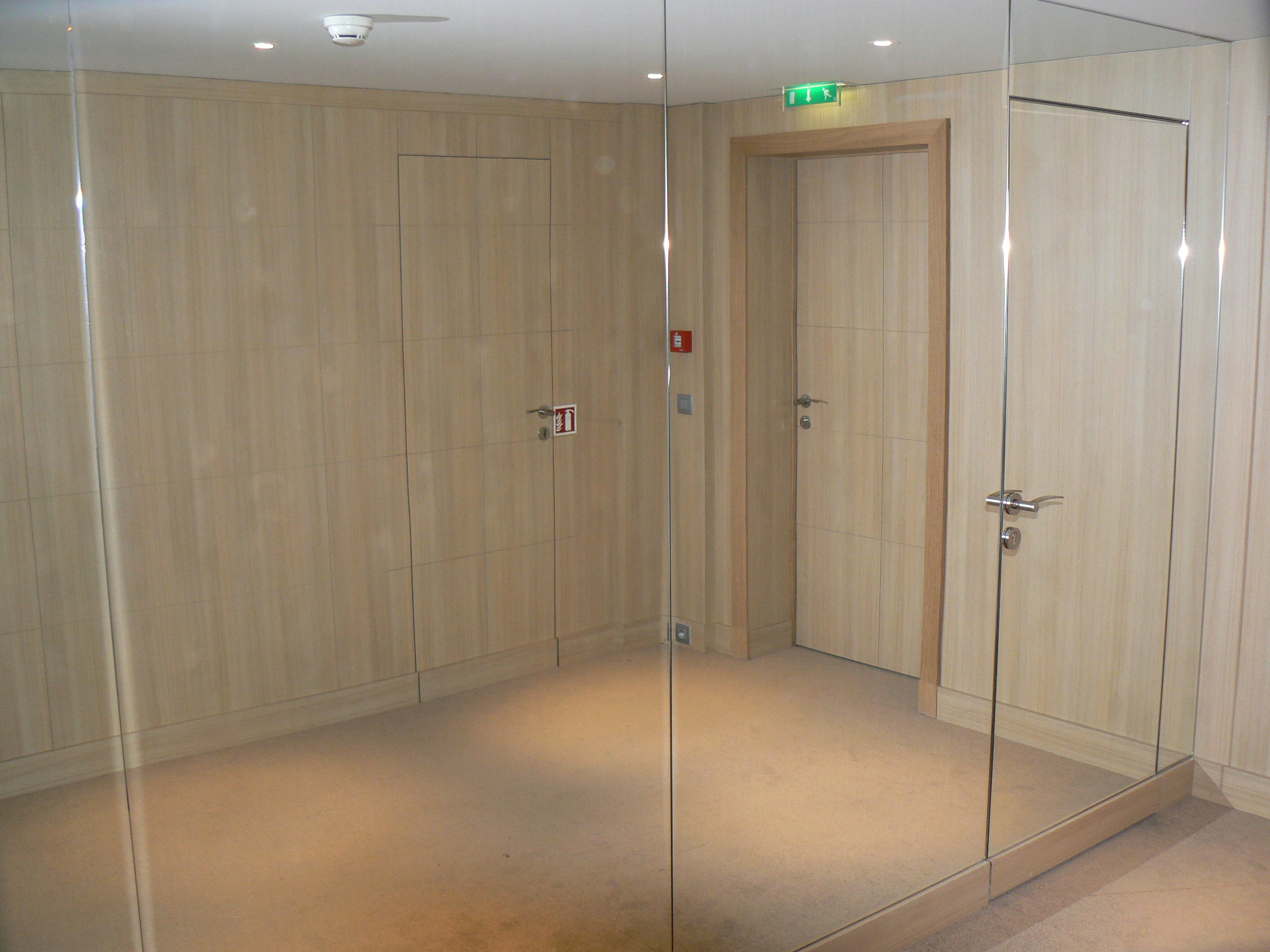 A room with a glass door and a mirror