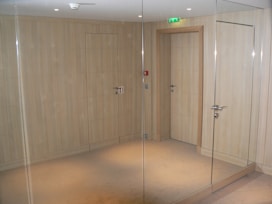 A room with a glass door and a mirror