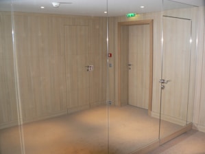 A room with a glass door and a mirror