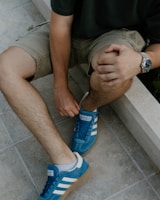 A man sitting on a ledge tying his shoes