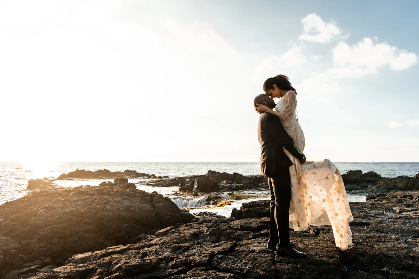 Couple on the terraces of Casapueblo Uruguay with the white curved building and warm golden sunset light surrounding them