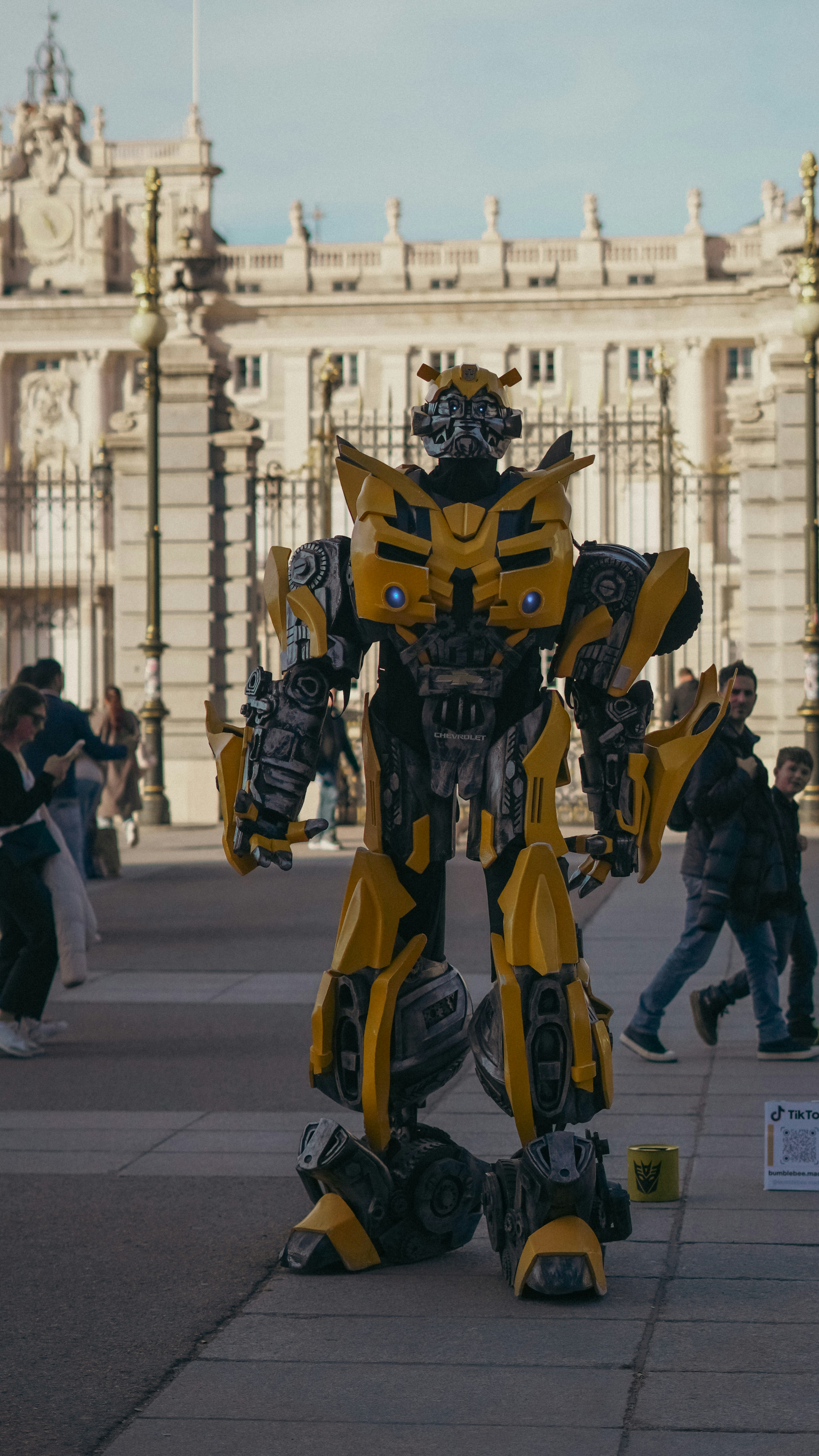 Robot kuning dan hitam berdiri di depan sebuah gedung