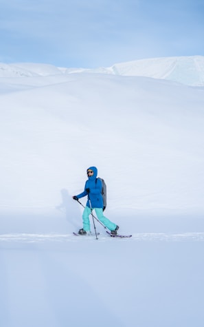 A person riding skis on a snowy surface