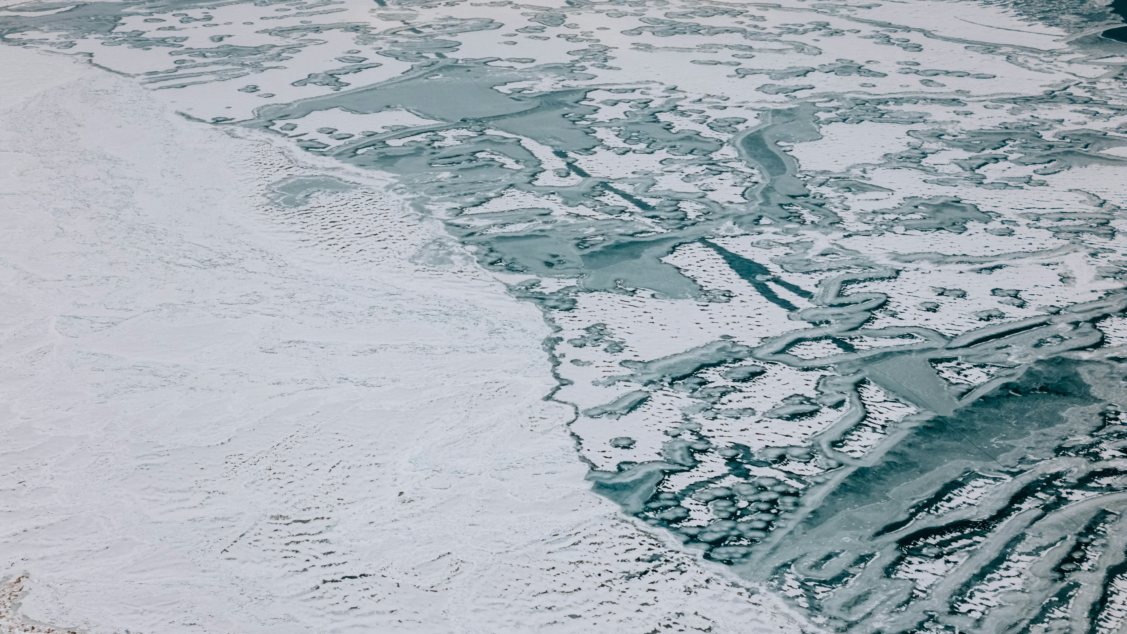 An aerial view of a large body of water covered in snow