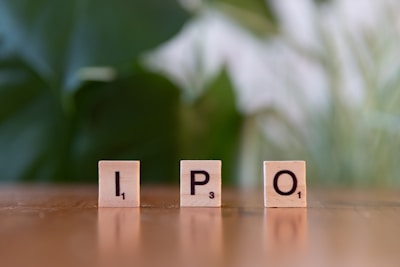 A wooden block spelling the word ipo on a table