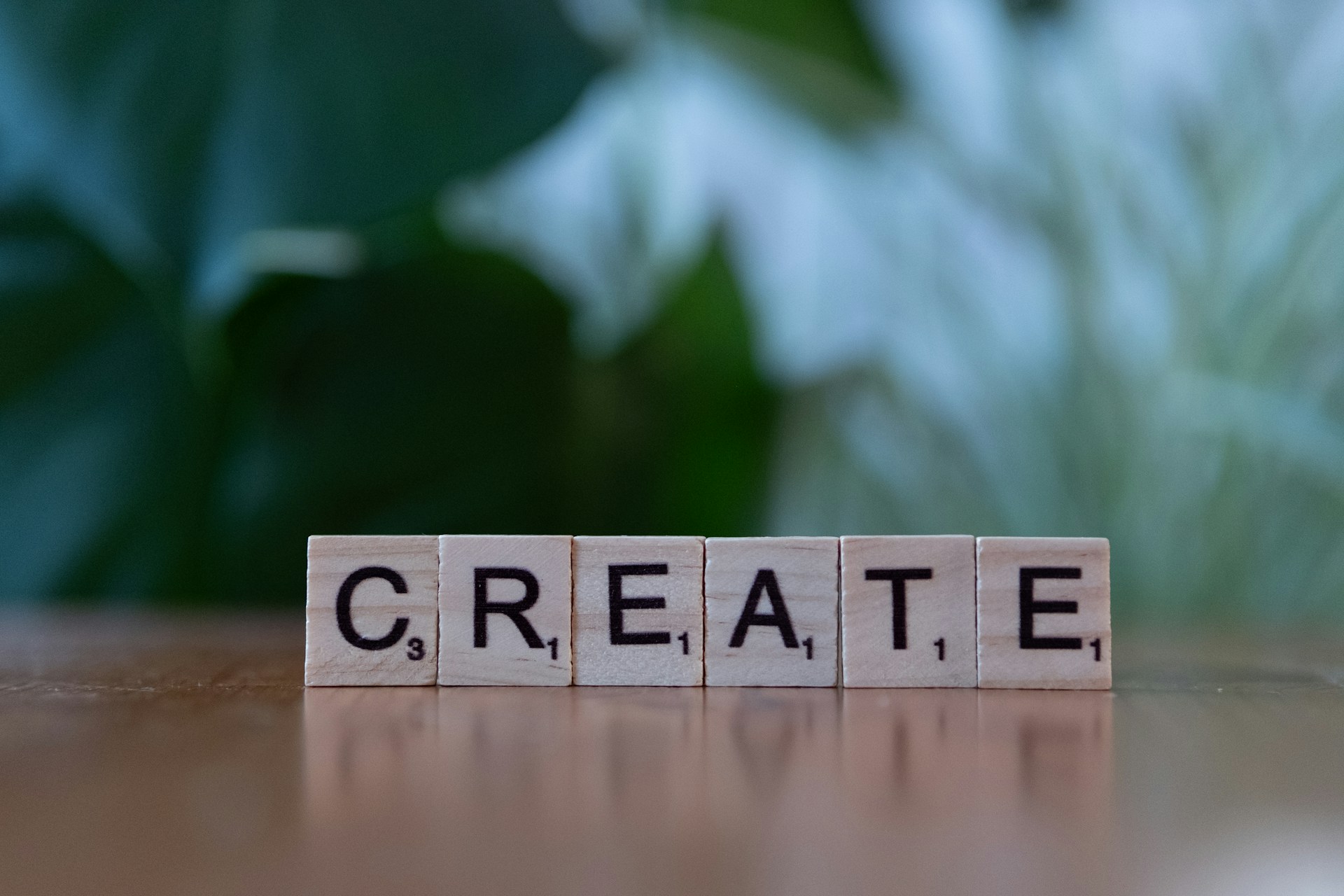 A wooden block spelling the word create on a table