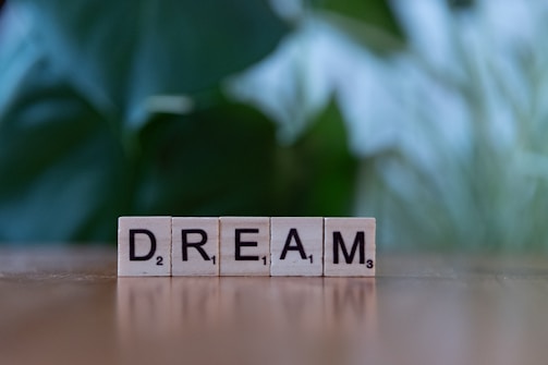 A scrabble block spelling dream on a table