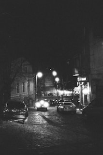 A black and white photo of a city street at night