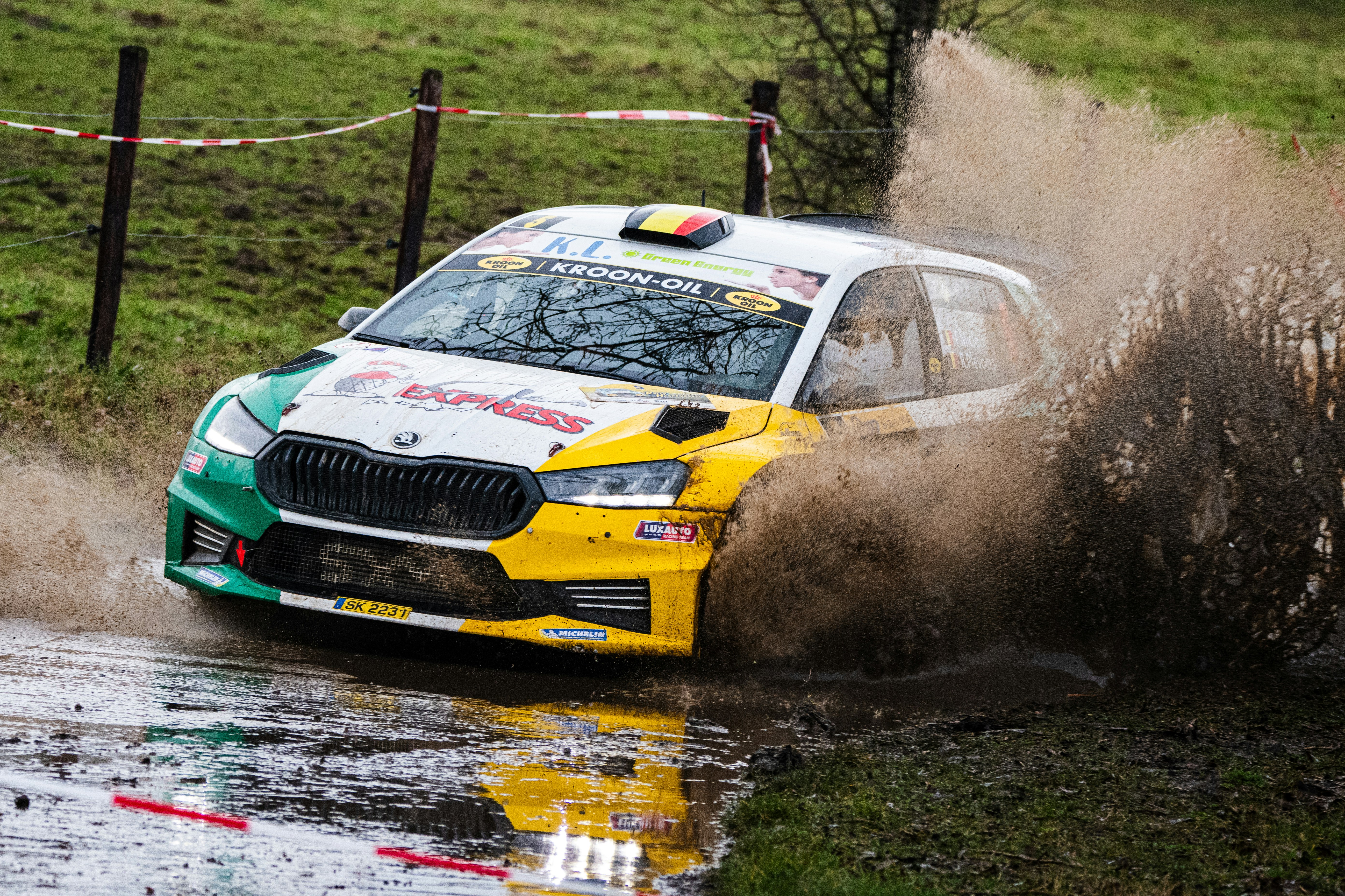 A car driving through a puddle in a field