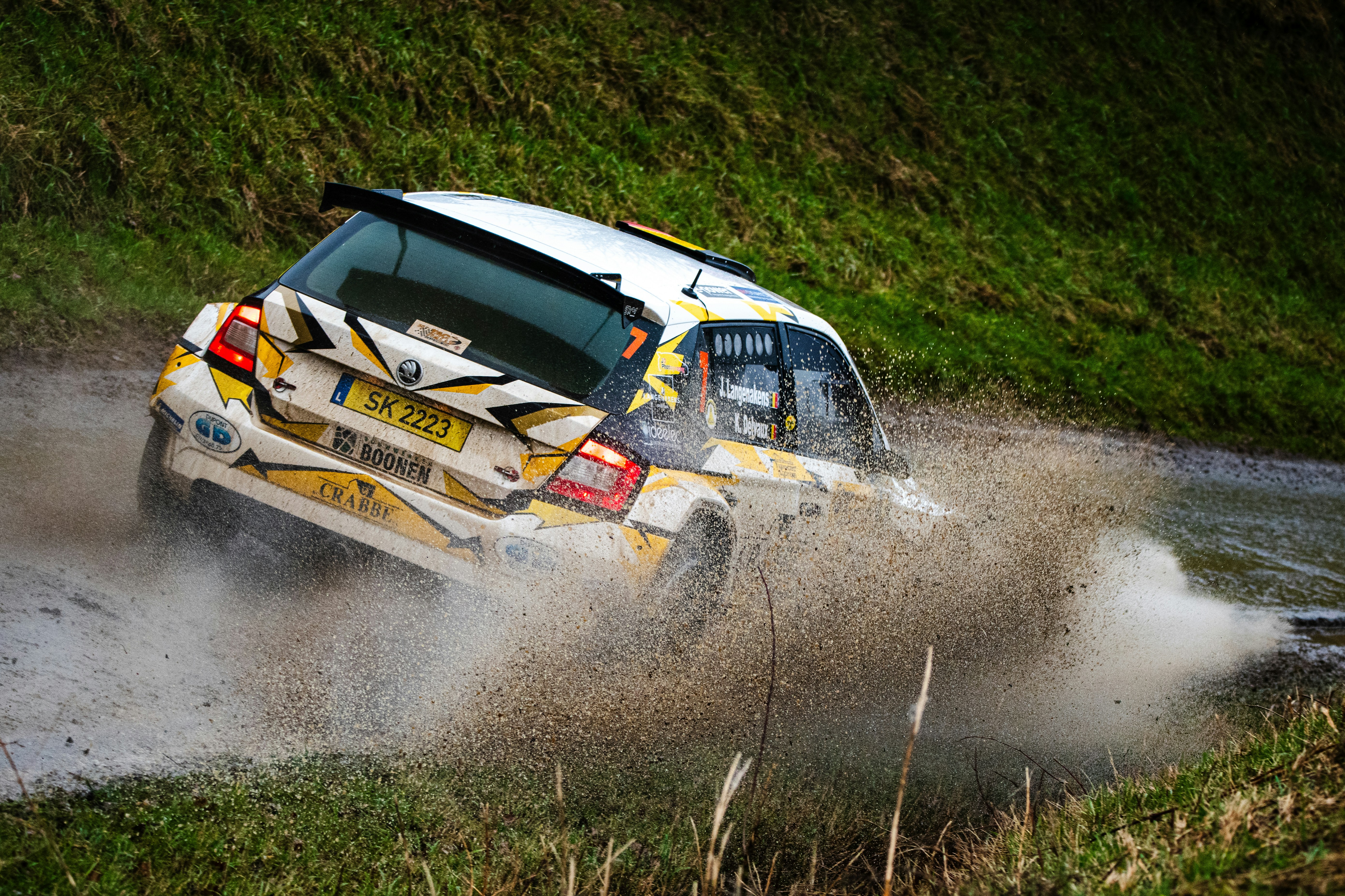 A rally car driving through a puddle of water