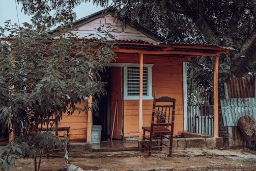 A small house with a porch and rocking chairs