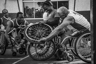 A group of men riding on the backs of wheelchairs