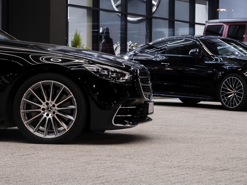 A couple of black cars parked in front of a building