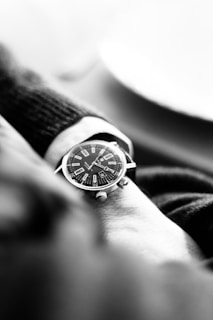 A black and white photo of a watch on someone's wrist
