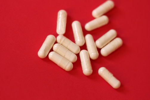 A pile of pills sitting on top of a red table