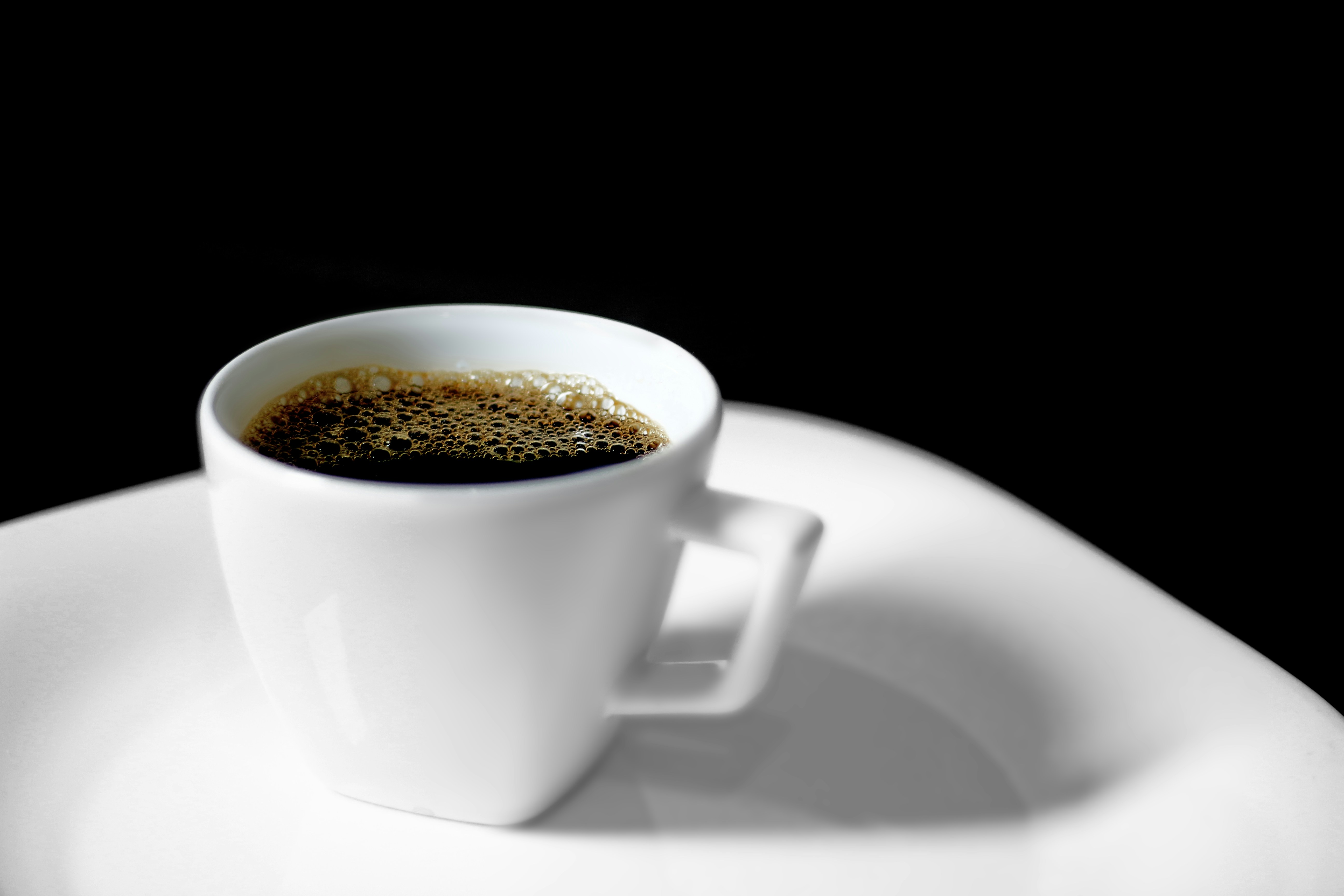 A cup of coffee sitting on top of a white plate