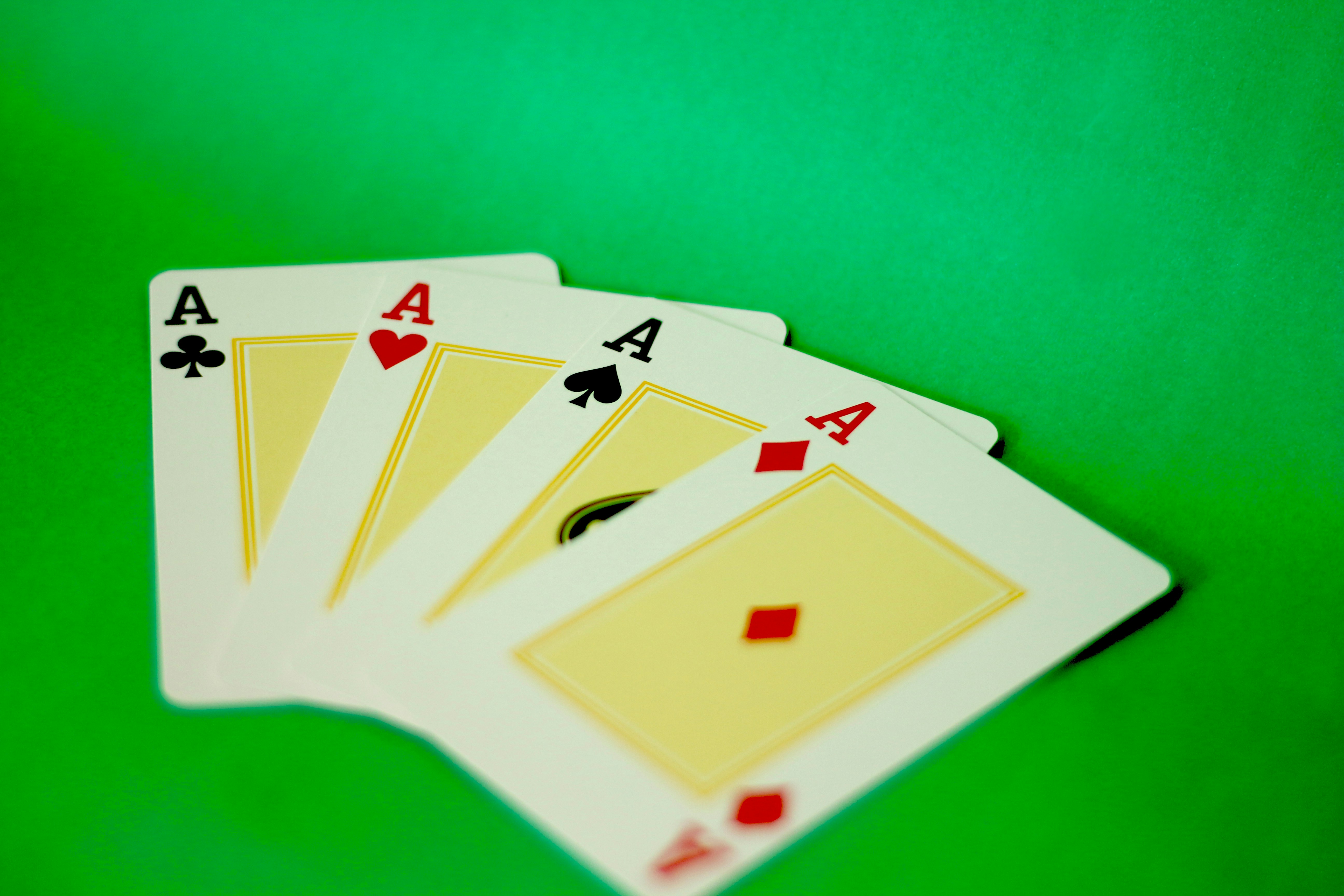 Four of a kind of playing cards on a green background