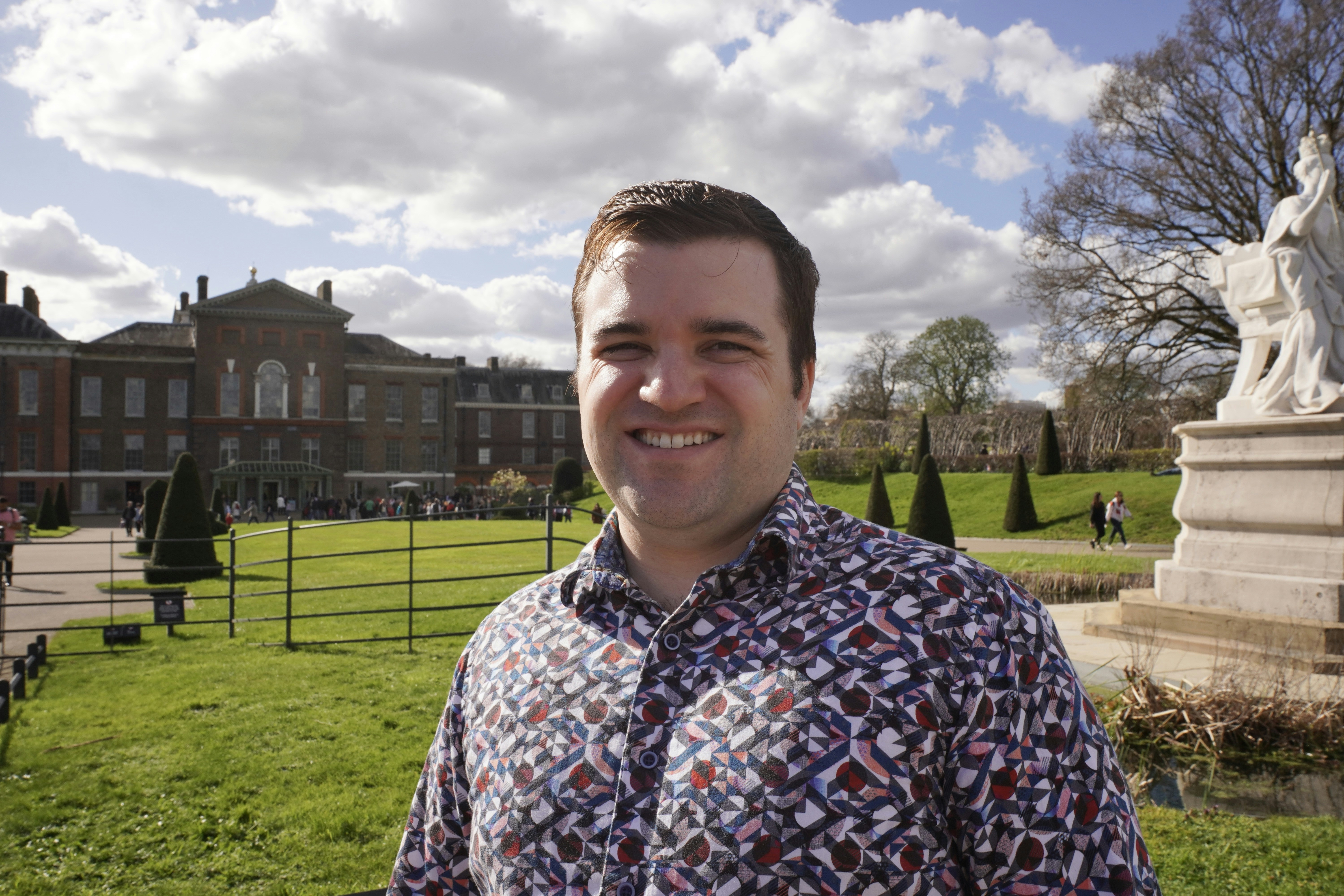 A man standing in front of a large building