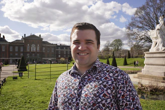 A man standing in front of a large building