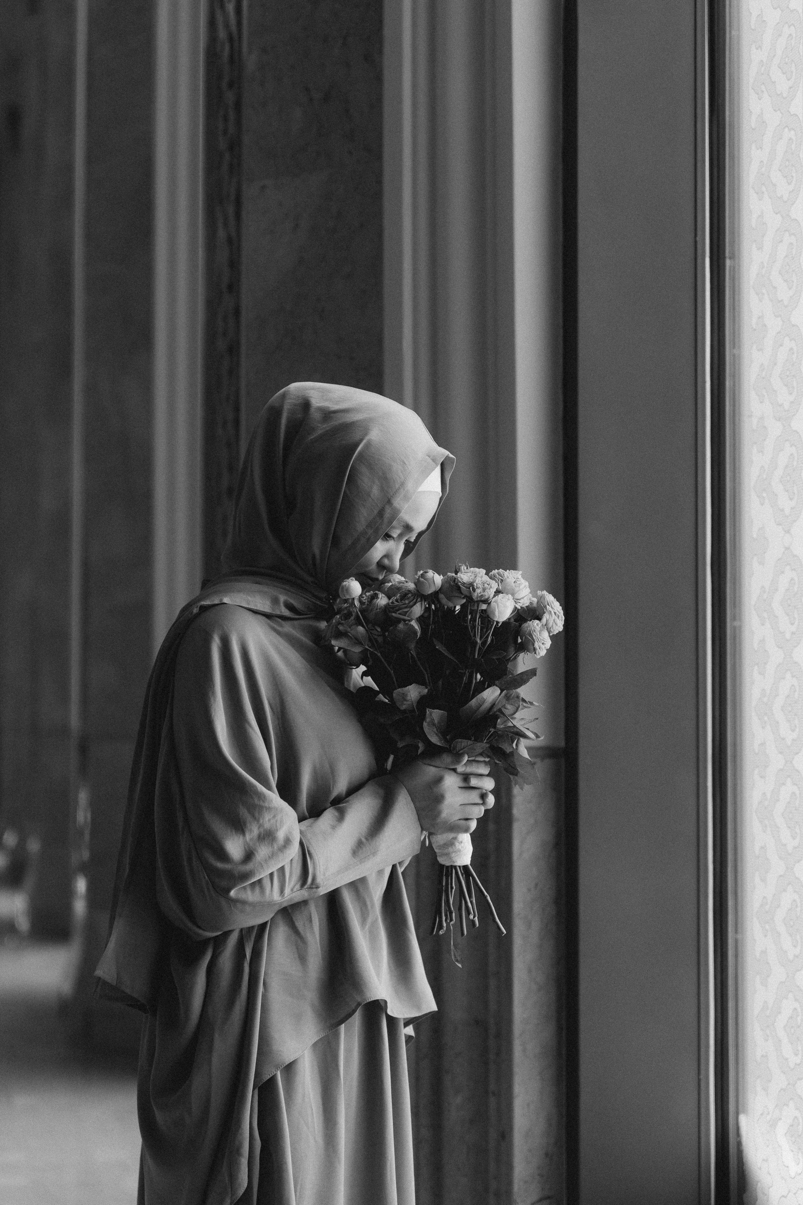 A woman in a robe holding a bunch of flowers