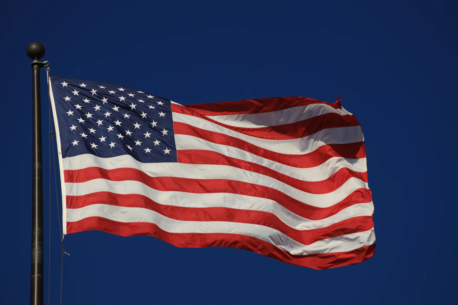 American flag waving against a deep blue sky