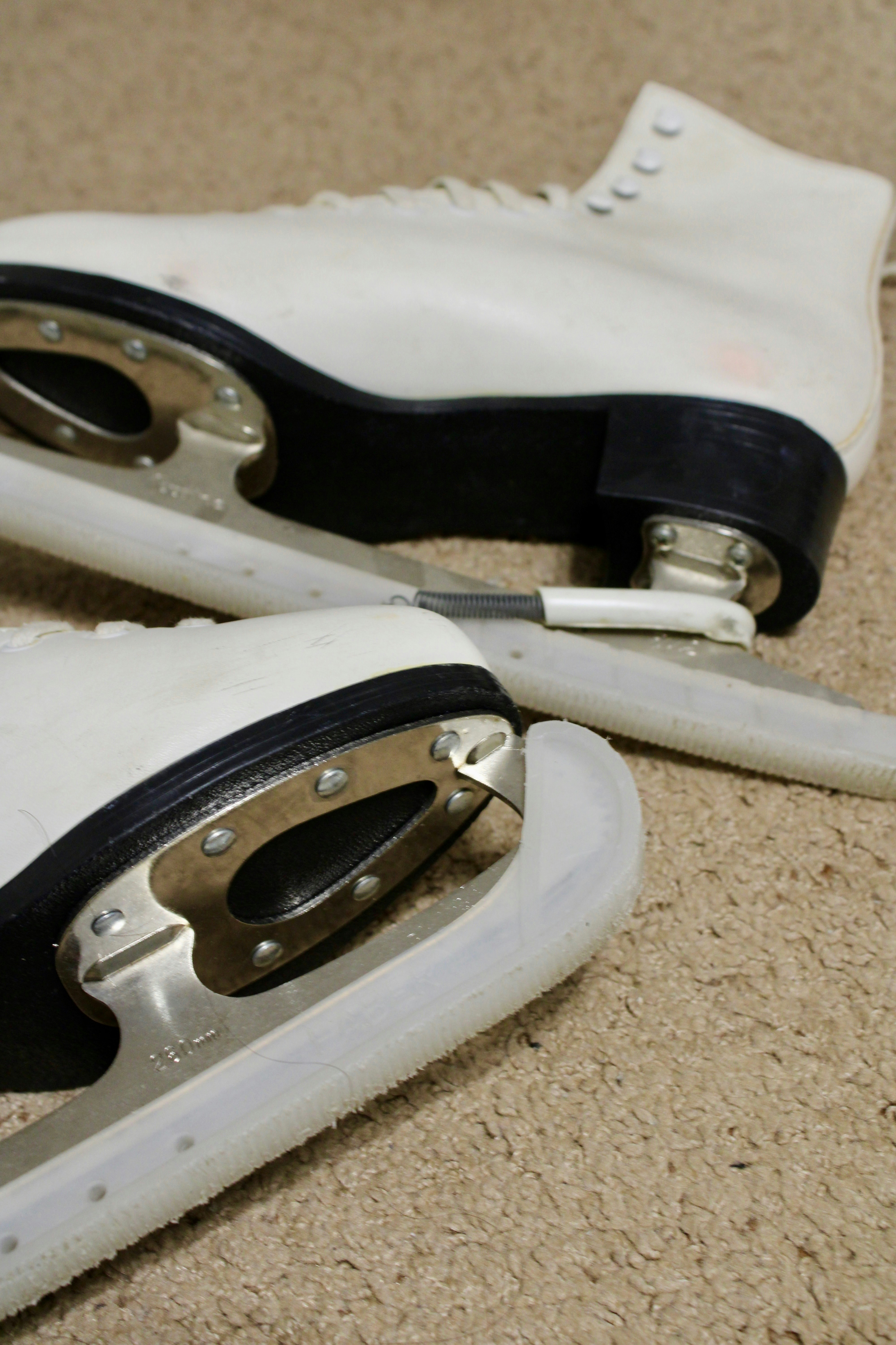A pair of white shoes sitting on top of a carpet