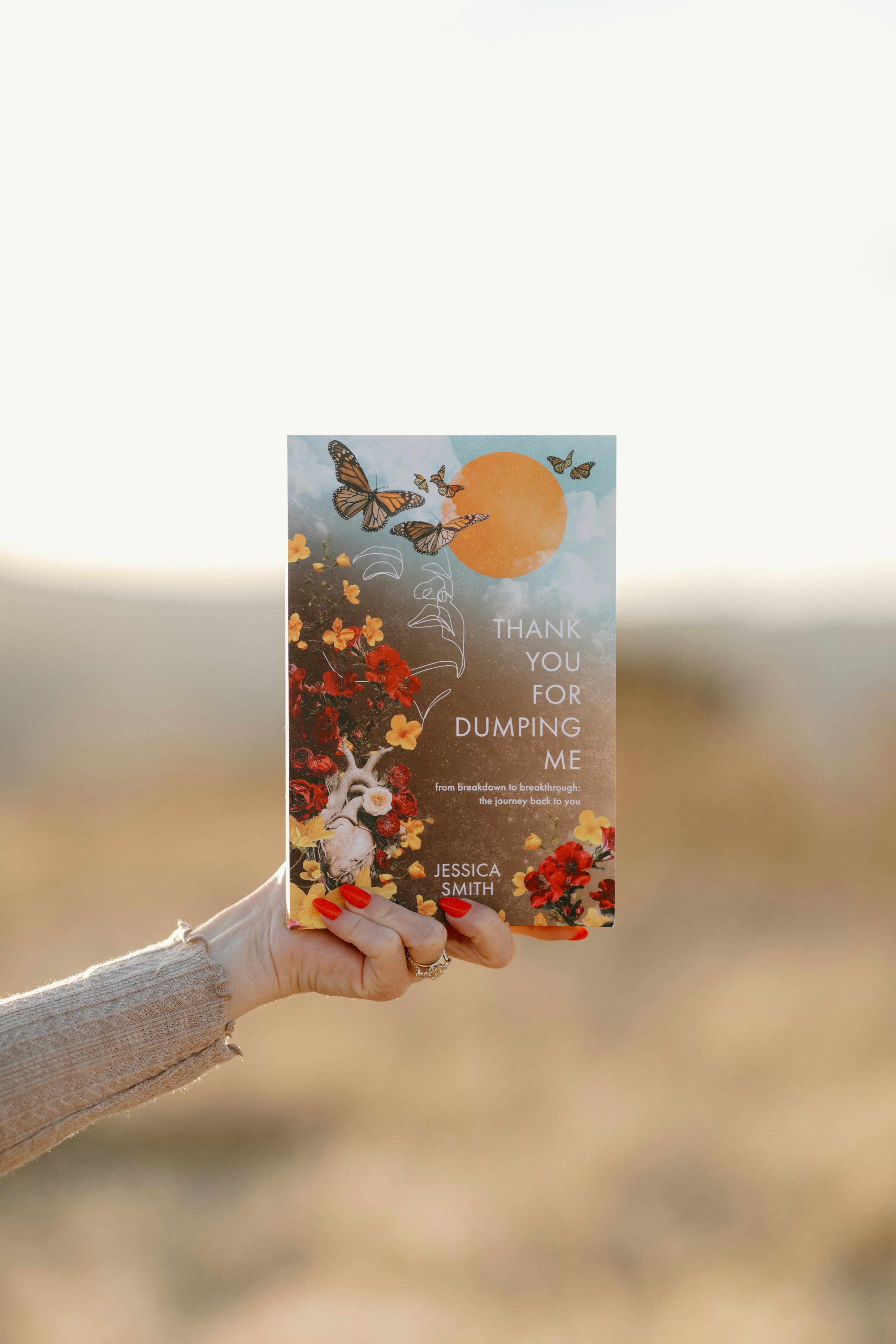 A woman holding up a card with a picture of a butterfly on it