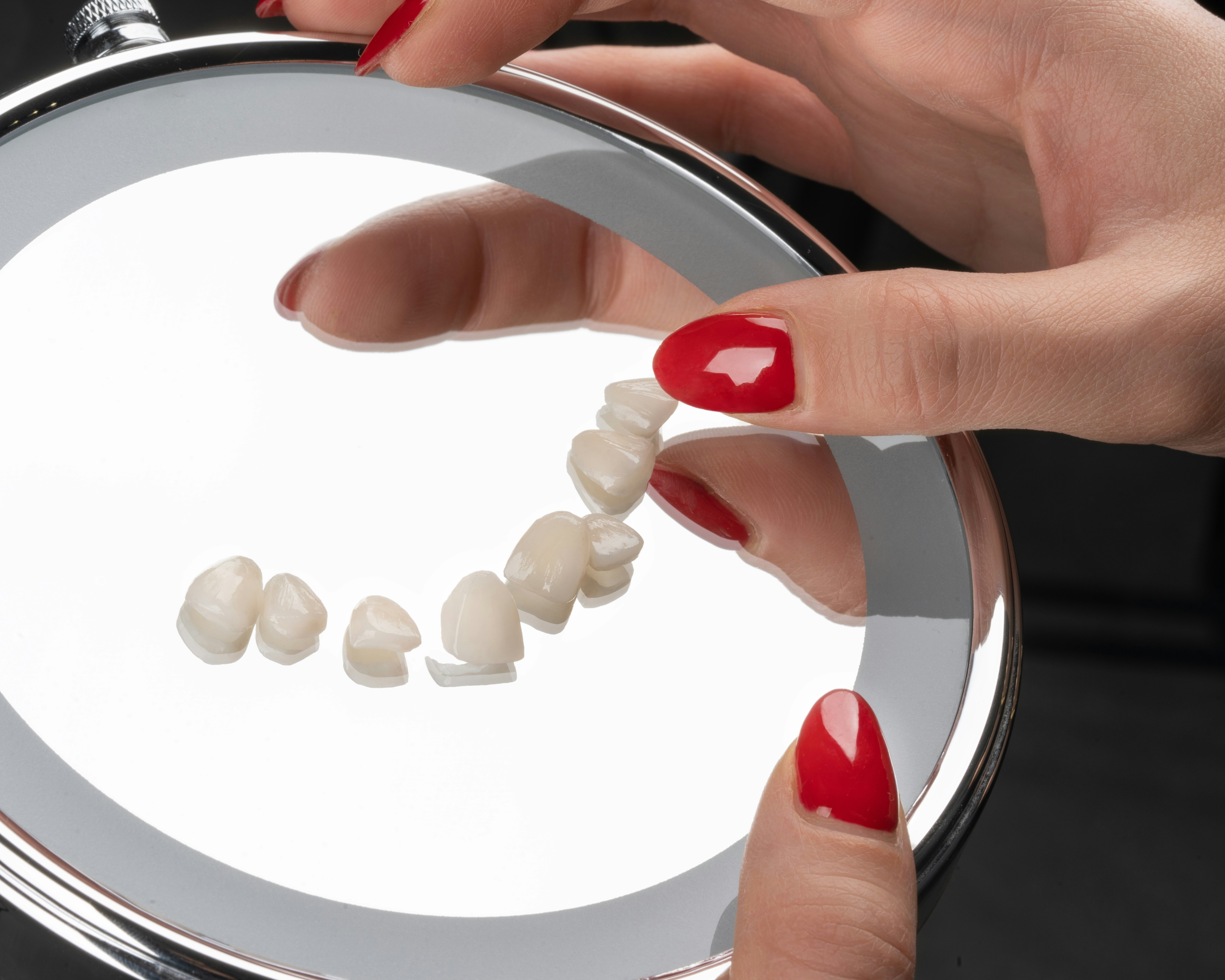 Die Hände einer Frau, die einen Spiegel mit Pillen darin halten