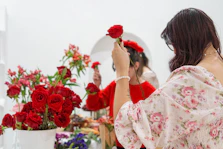 A woman standing in front of a mirror holding a flower