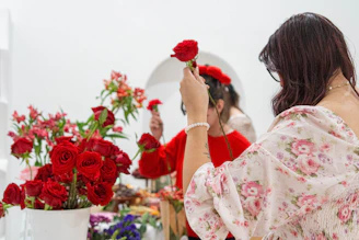A woman standing in front of a mirror holding a flower