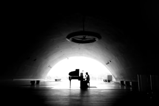 A man sitting at a piano in a dark tunnel