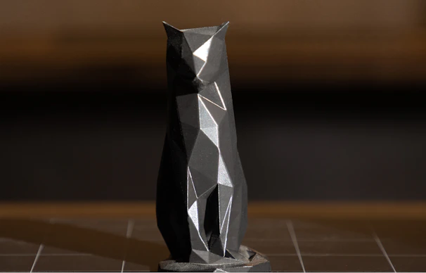 A black and silver vase sitting on top of a tiled floor