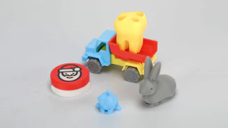 A small toy truck with a small toy elephant